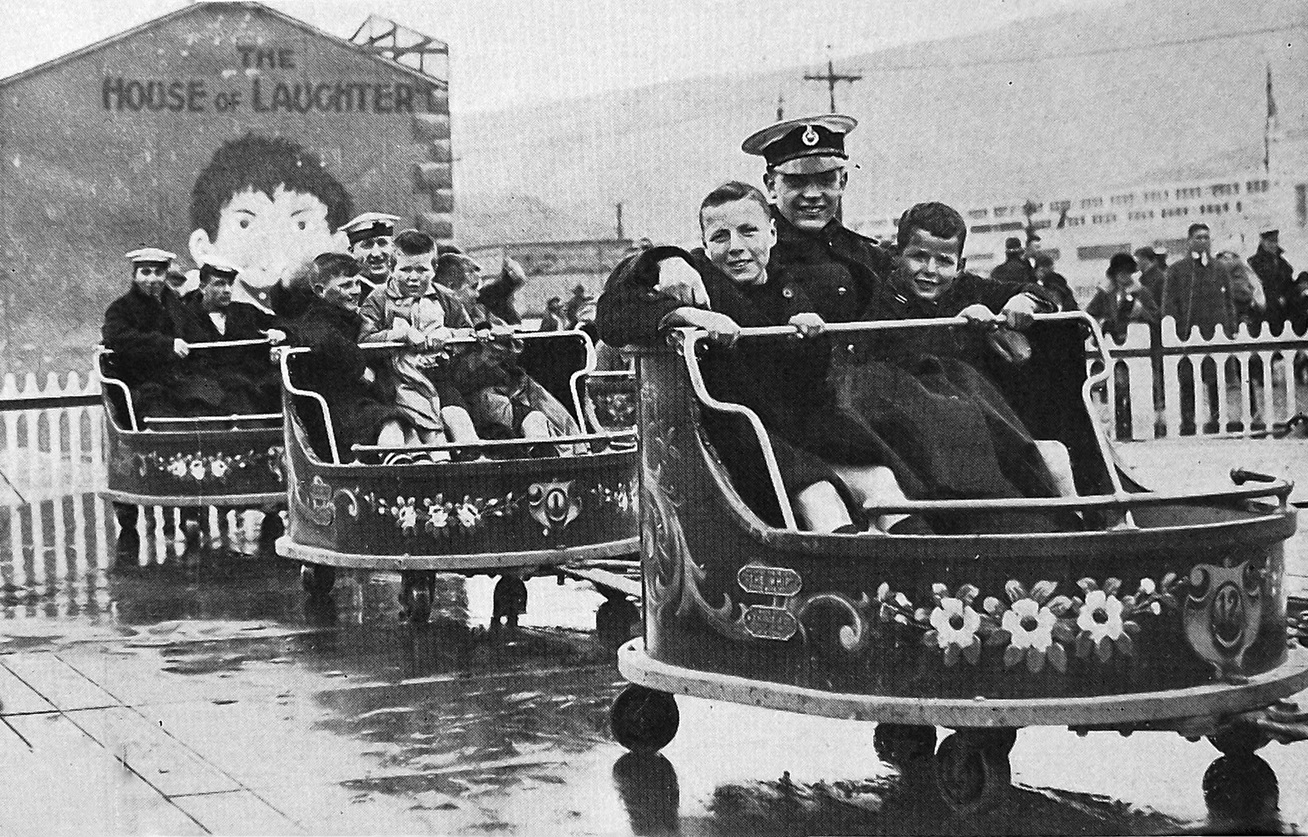 Sailors of HMS Dunedin take a group of orphans for a joyride on The Whip, one of the attractions...