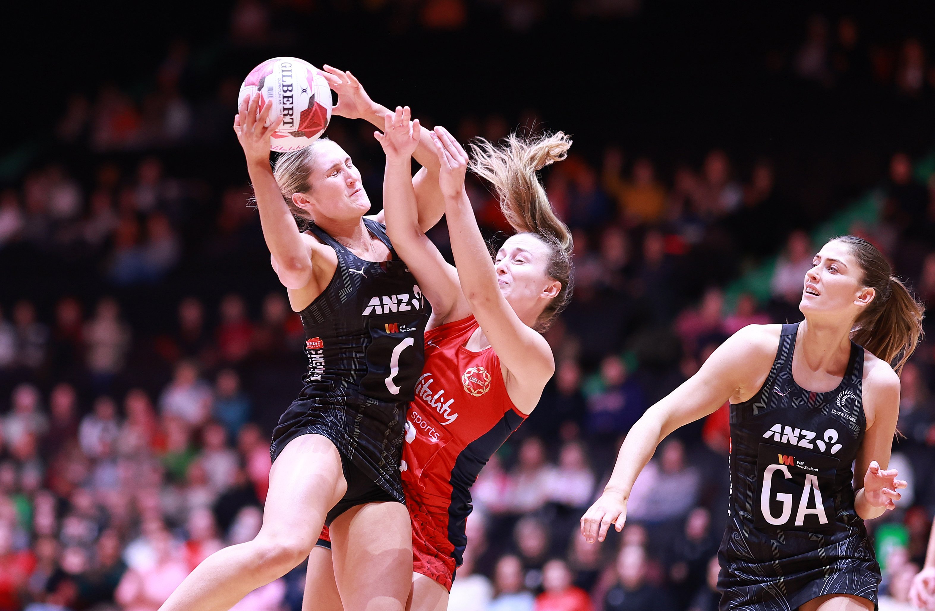 Silver Ferns midcourter Maddy Gordon takes the ball under pressure from England centre Amy Carter...