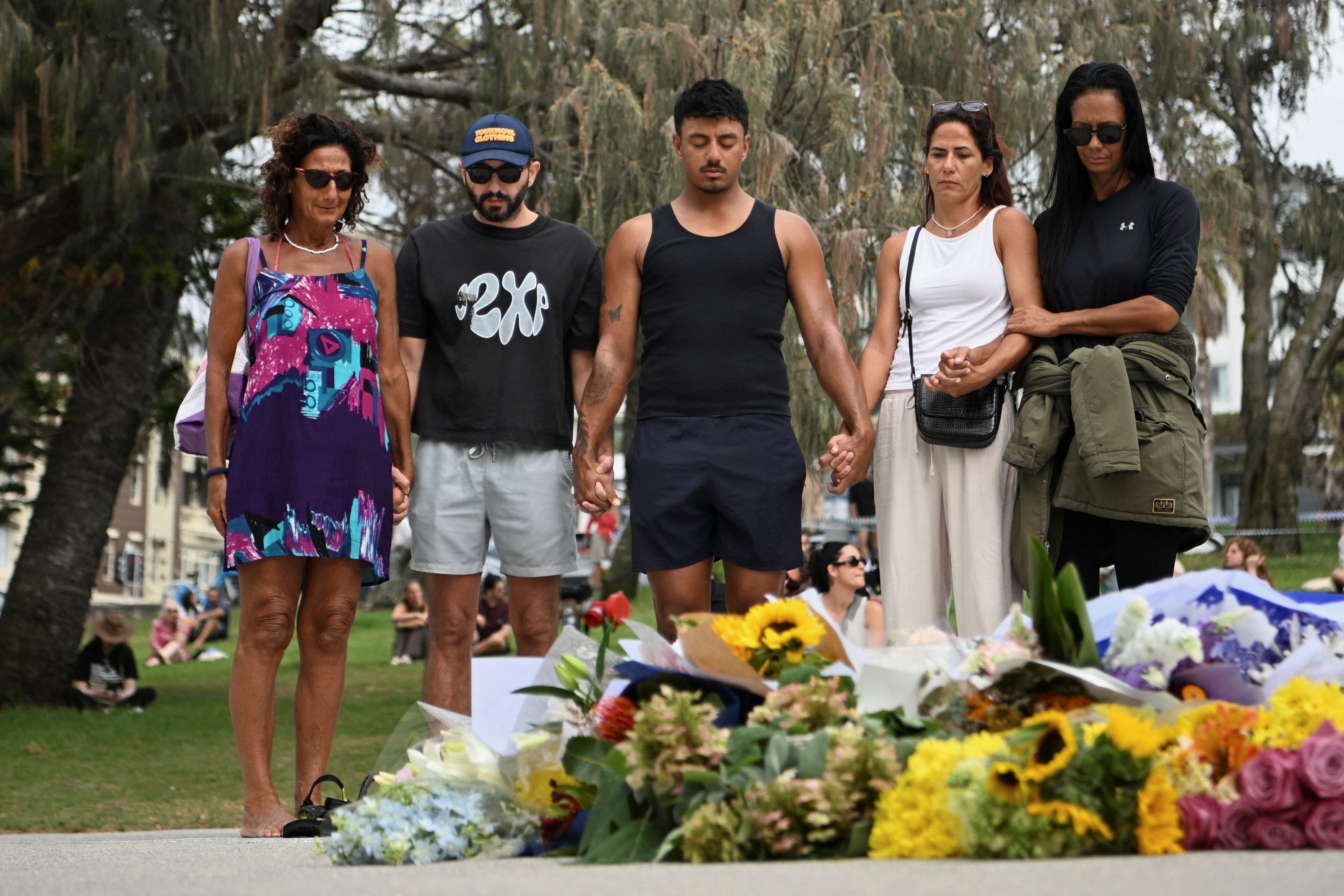 Mourners at an improvised memorial for those killed at Bondi. PHOTO: REUTERS
