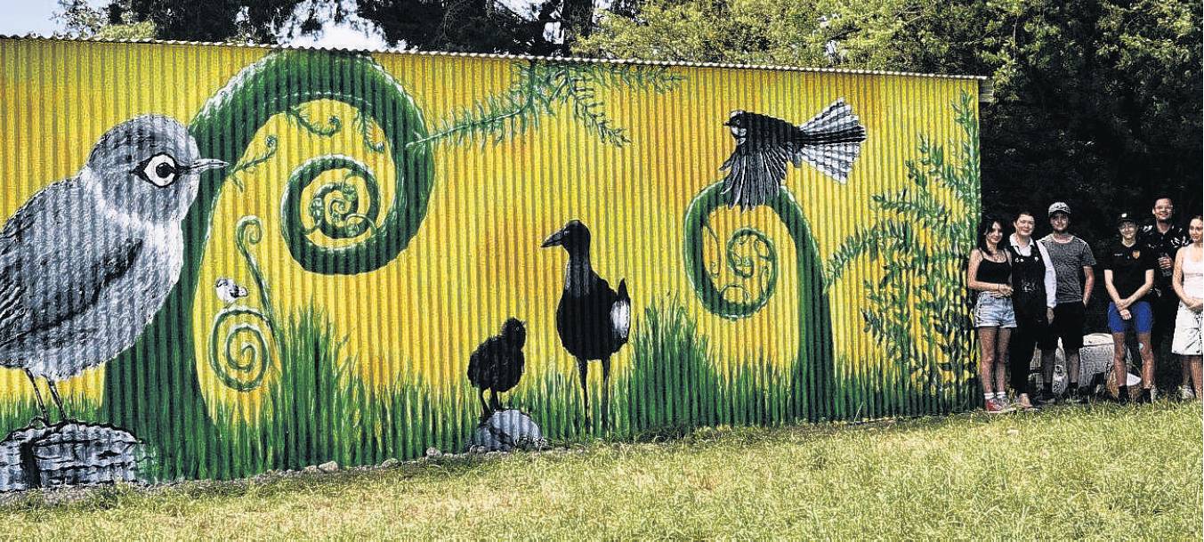 The designer of the mural on the back of the Hauora Hub shed, Addison Spragg (right), with others...