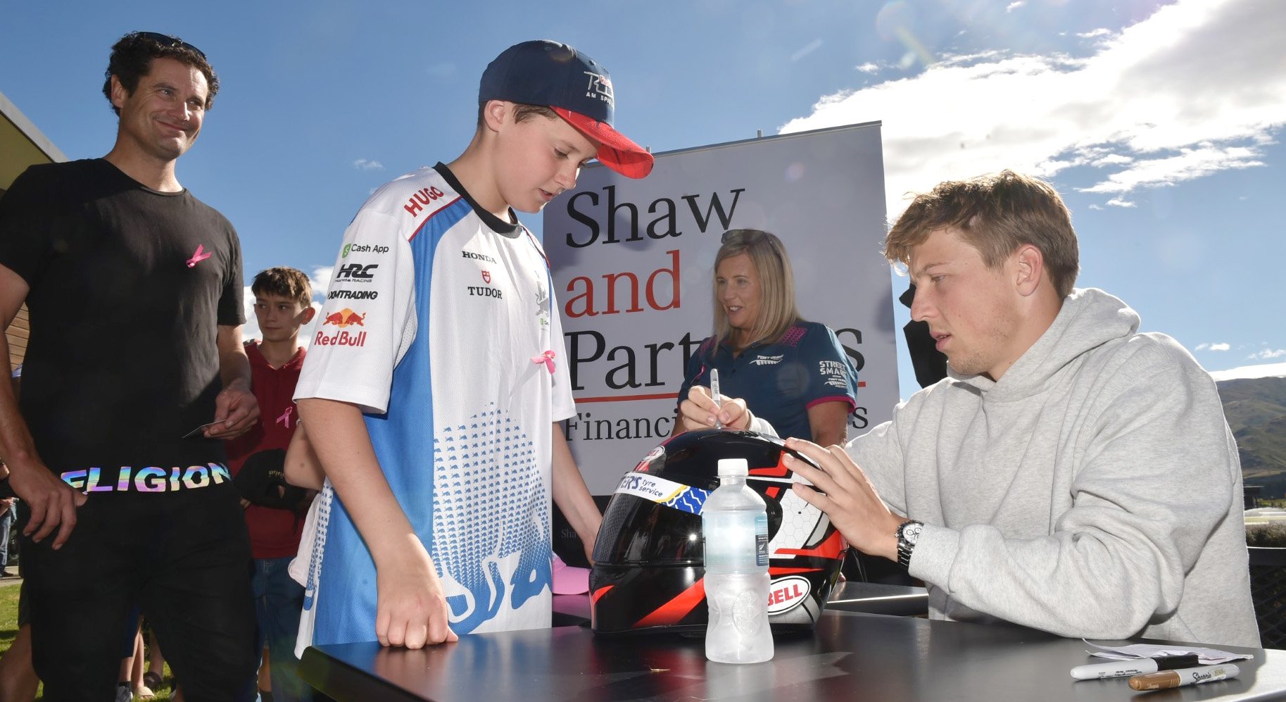 Scott Hodges watches as his son Fraser (12), both of Invercargill, gets his karting helmet signed...