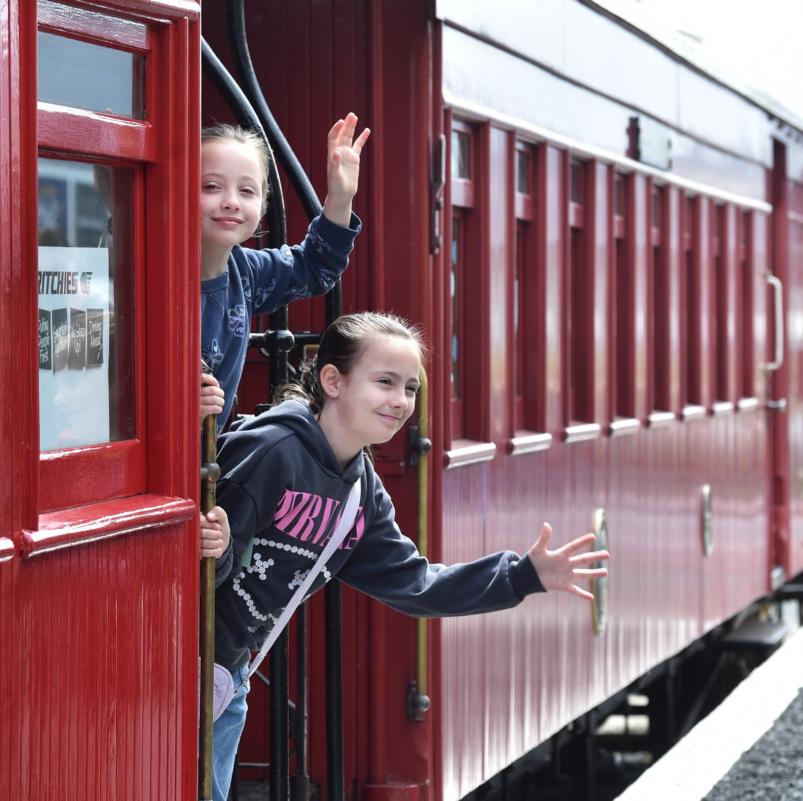 Olivia, 8 (left), and Hannah, 9, Bottomley take a ride in an Ocean Beach Railway carriage. Photo:...