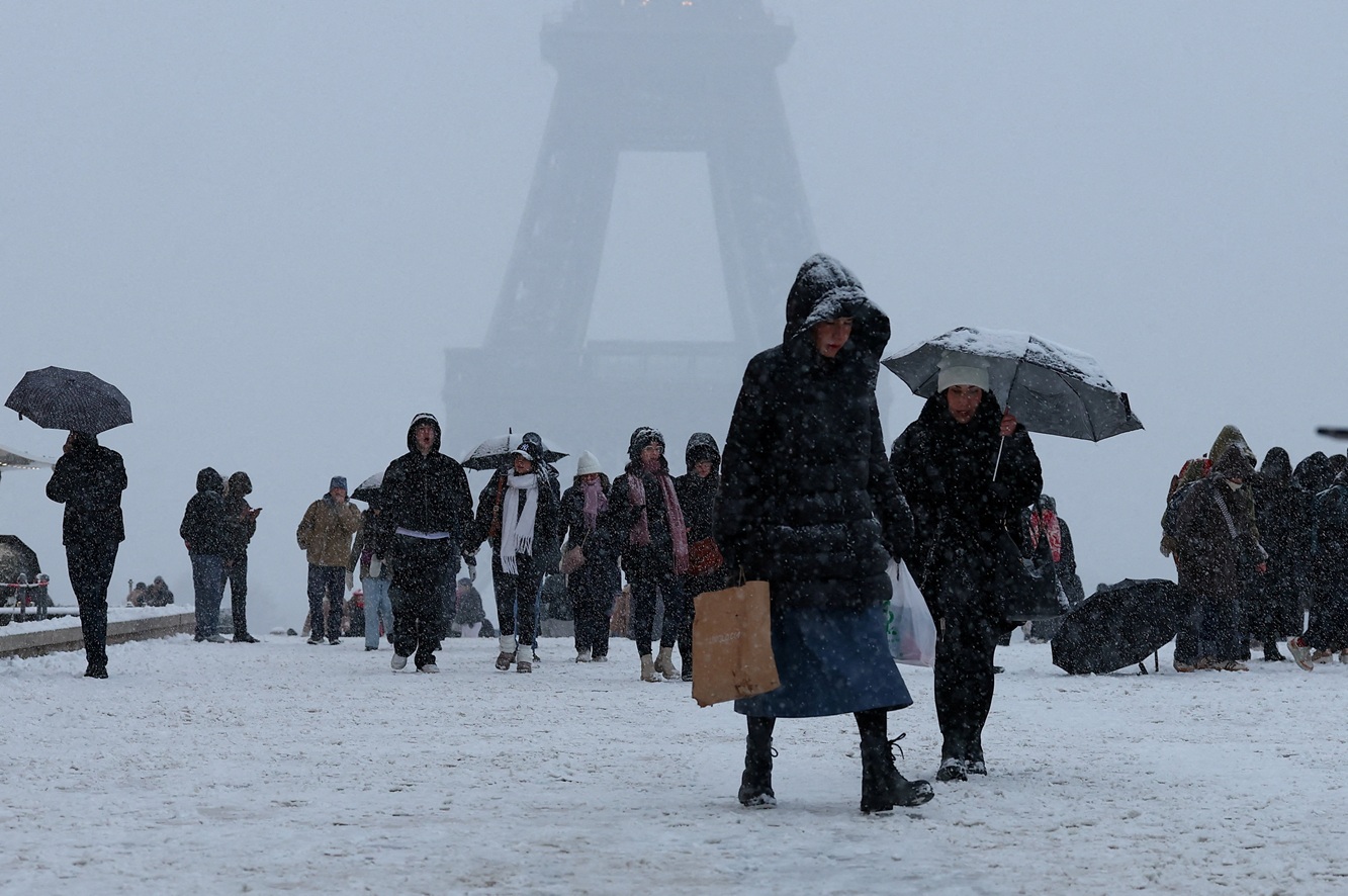 People walk in the snow-covered Trocadero square near the Eiffel Tower in Paris. Photo: Reuters