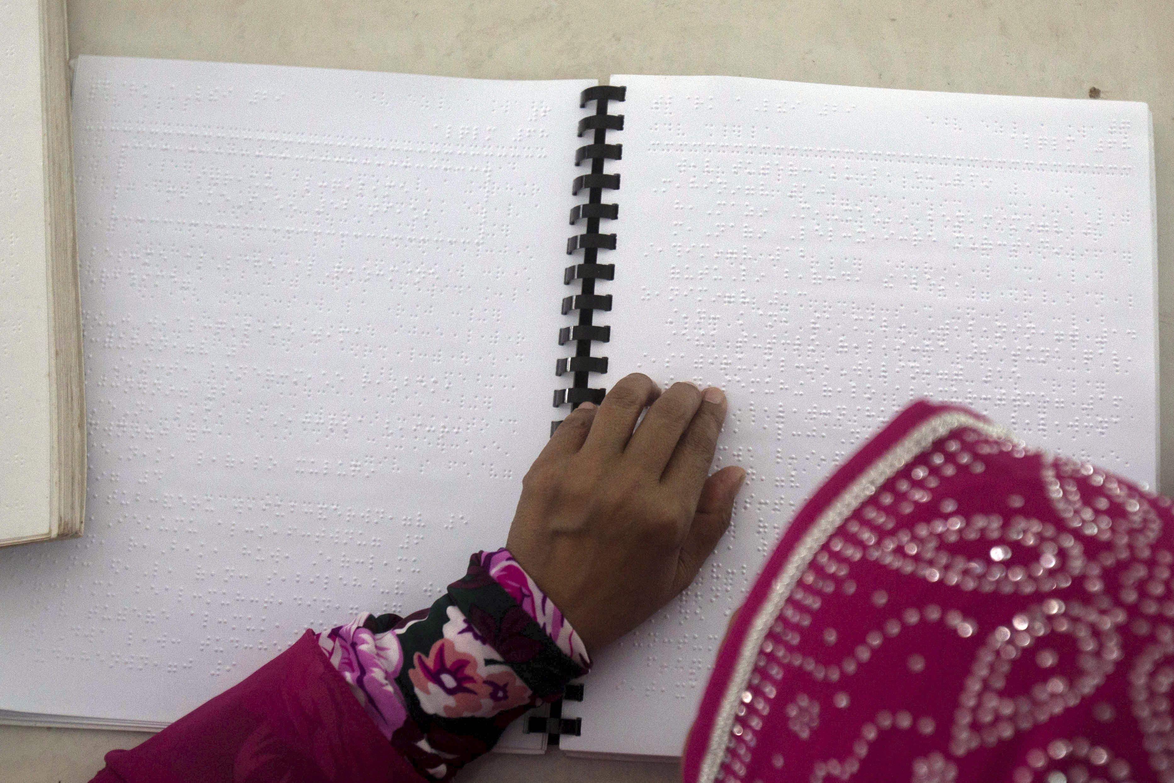 A blind woman reads the Koran, Islam’s holy book, written in Braille. PHOTO: AP