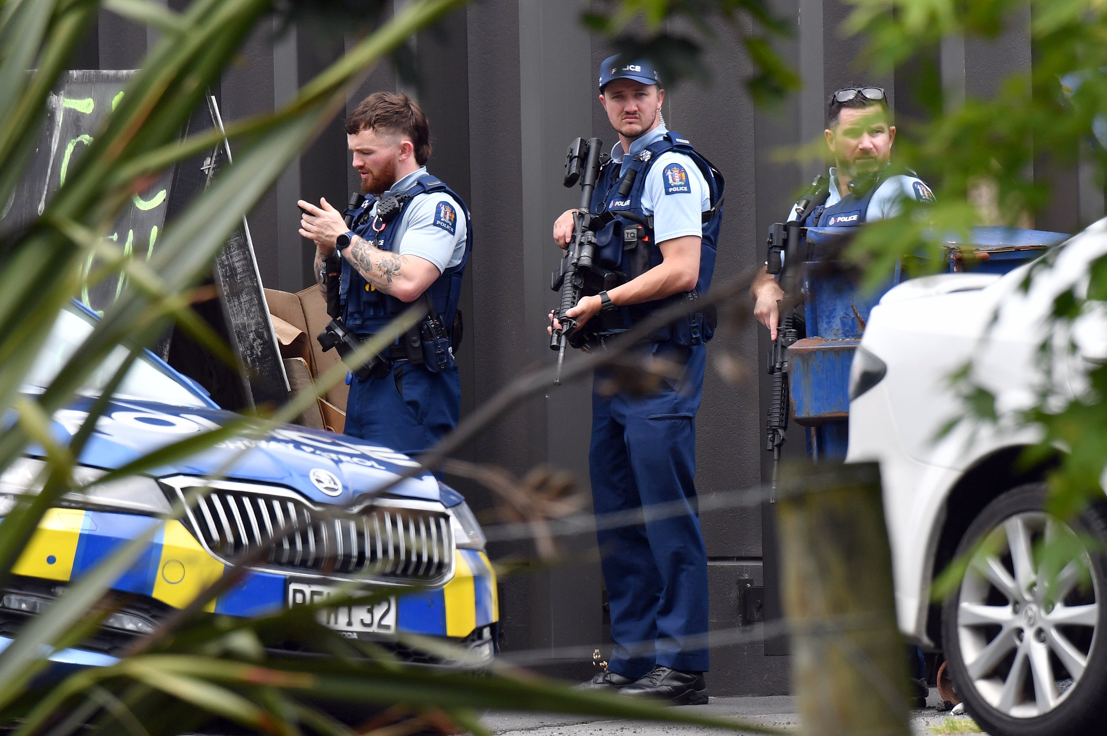 Armed police keep an eye out in South Rd yesterday for two men wanted in relation to several...