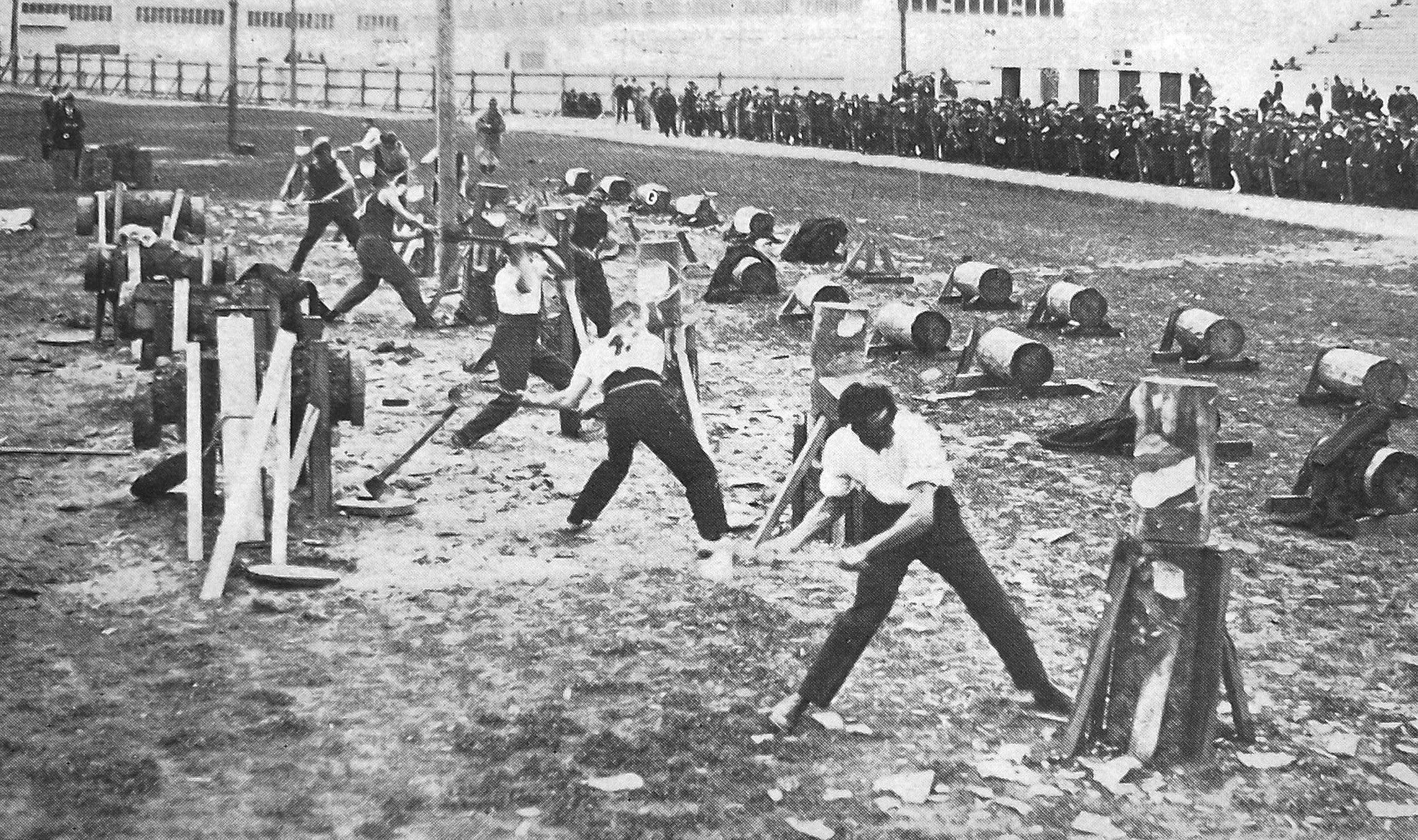 L.J. Williams (front), of West Coast, swings his axe to win the 12-inch standing chop event in an...