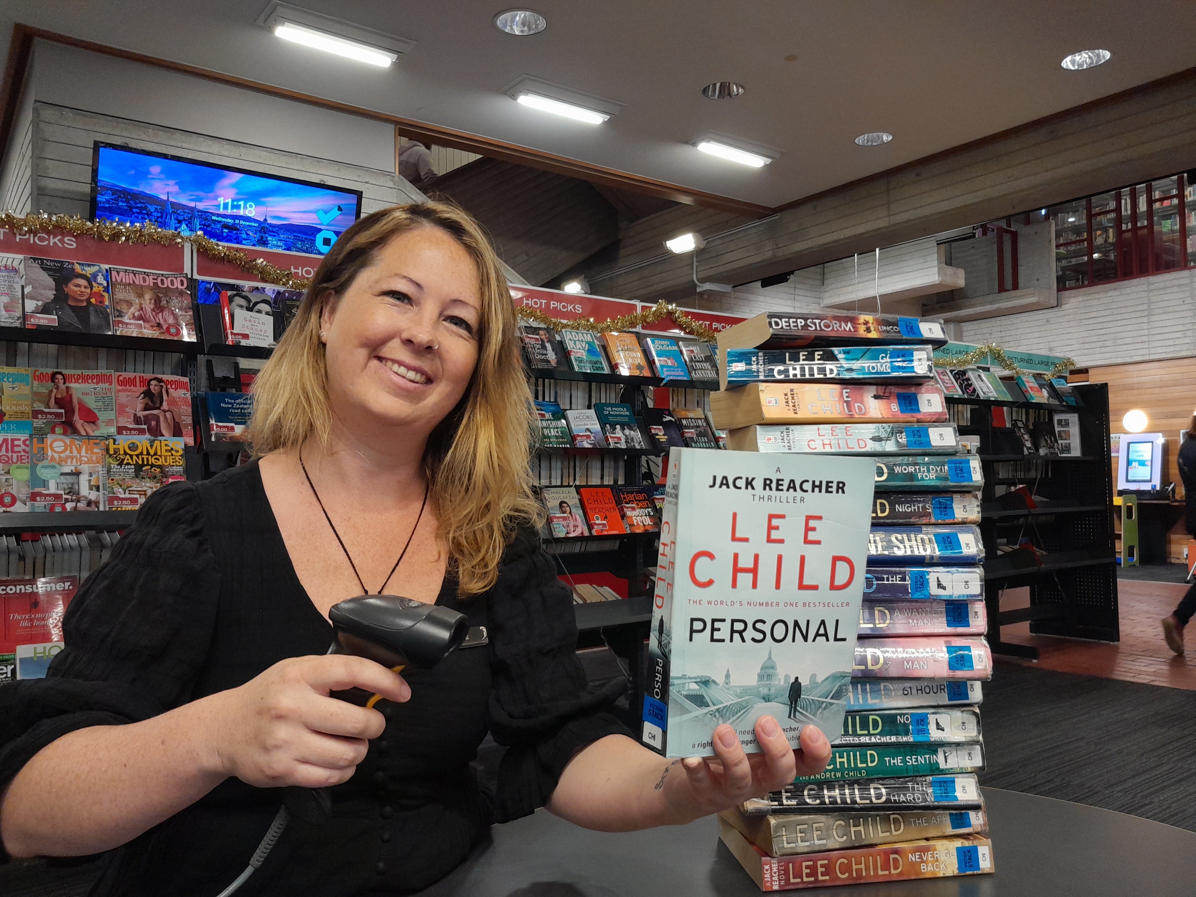 Dunedin City Libraries library assistant Kelcie Watkins-Dooley checks out a stack of books by...
