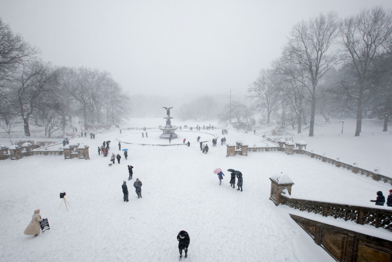 People walk around Central Park as a major winter storm spreads across a large swath of the...