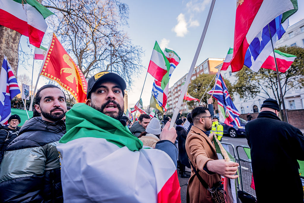 Demonstrators wave flags outside the Iranian Embassy in London during a rally in support of the...
