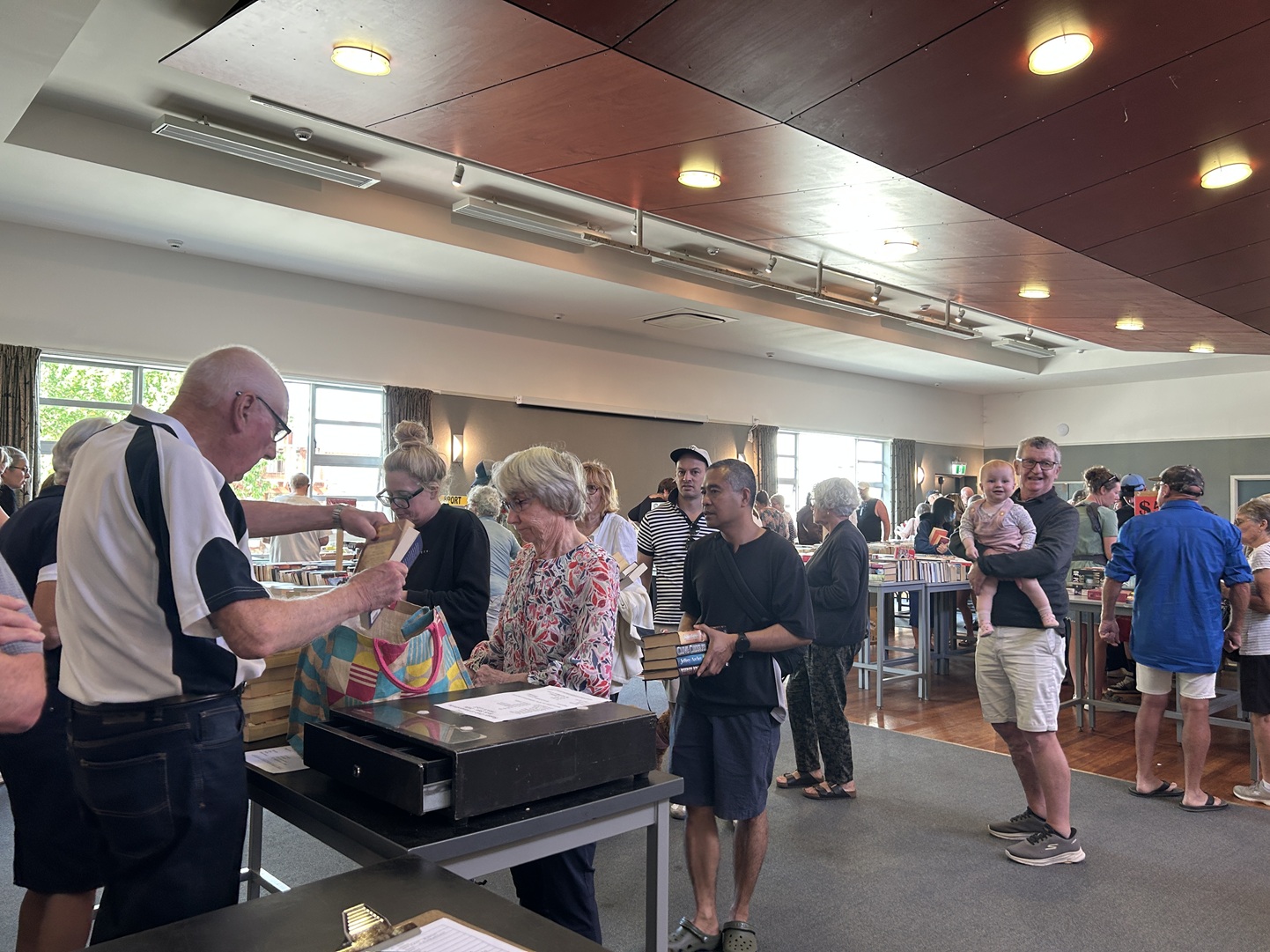 Alexandra Rotary member Murray Wham sells books as the customers queue at the Alexandra Rotary...