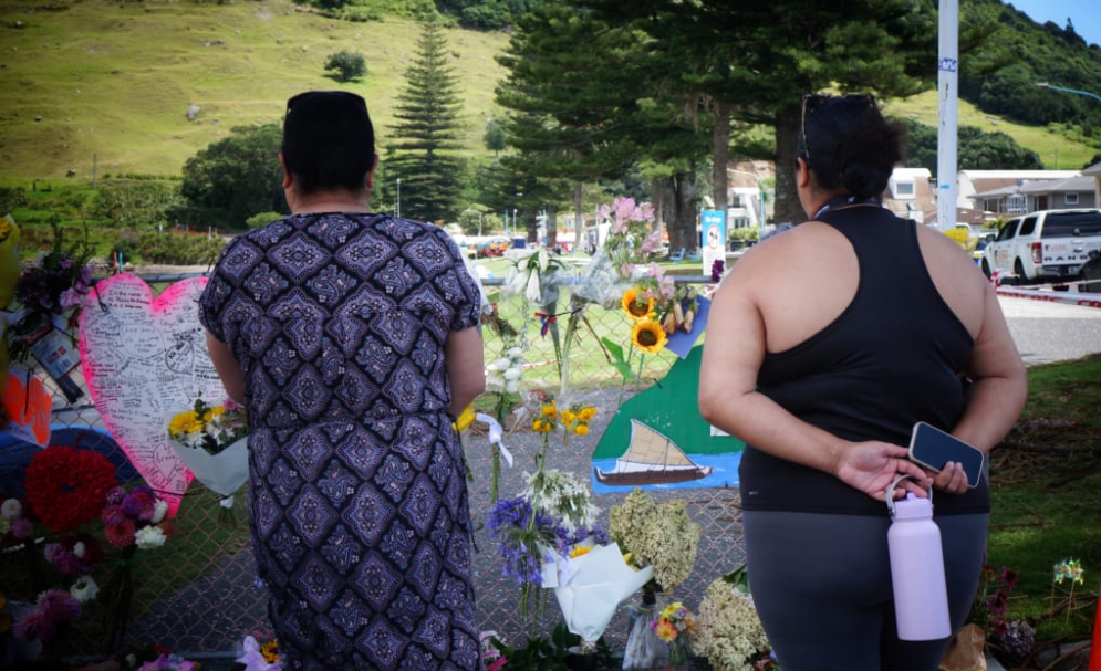 Flowers and messages have been placed on a fence near the  landslip site. Photo: RNZ 