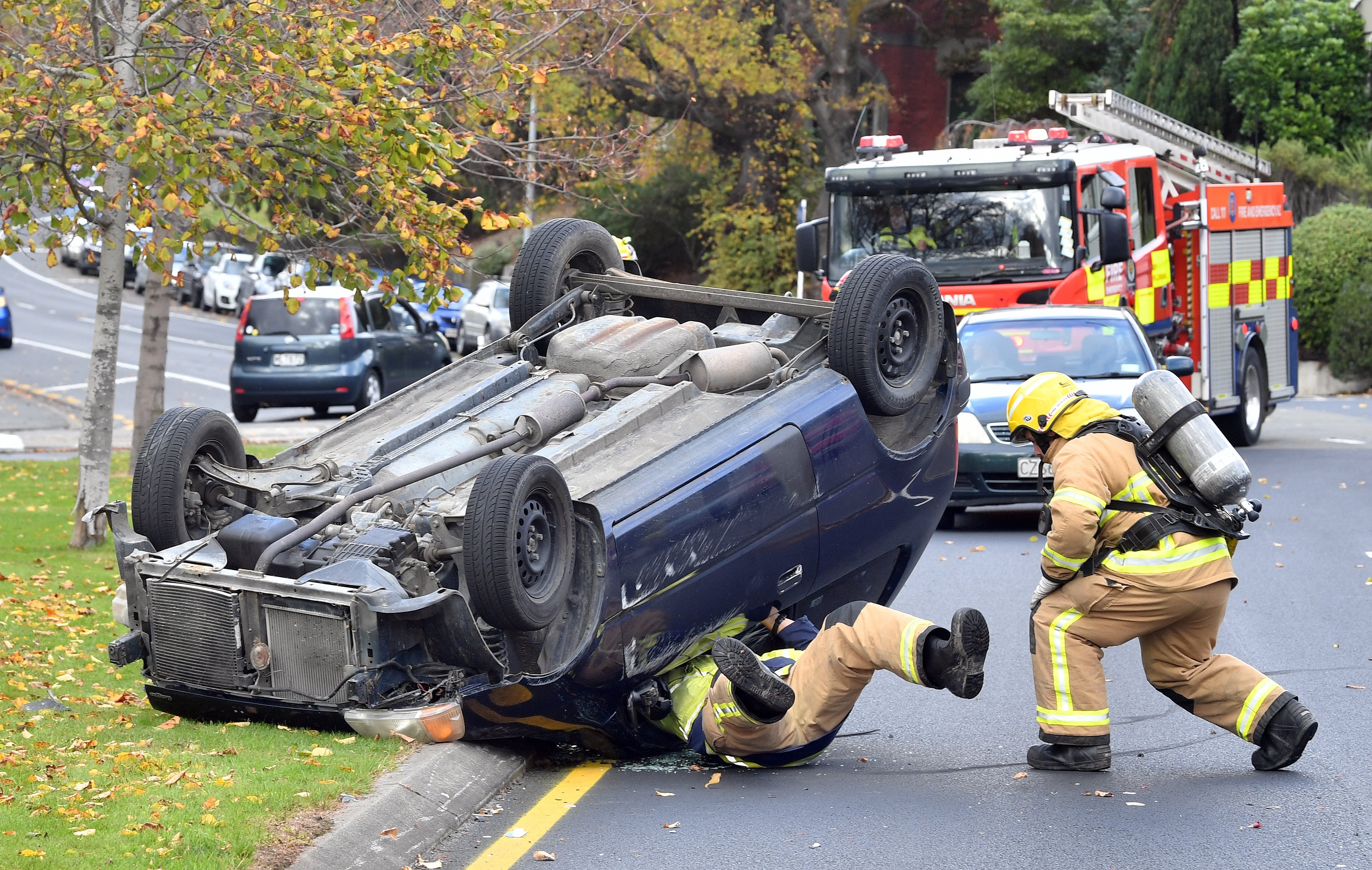 Do not always believe what you see. This firefighter is not trapped under a car, he has squeezed...