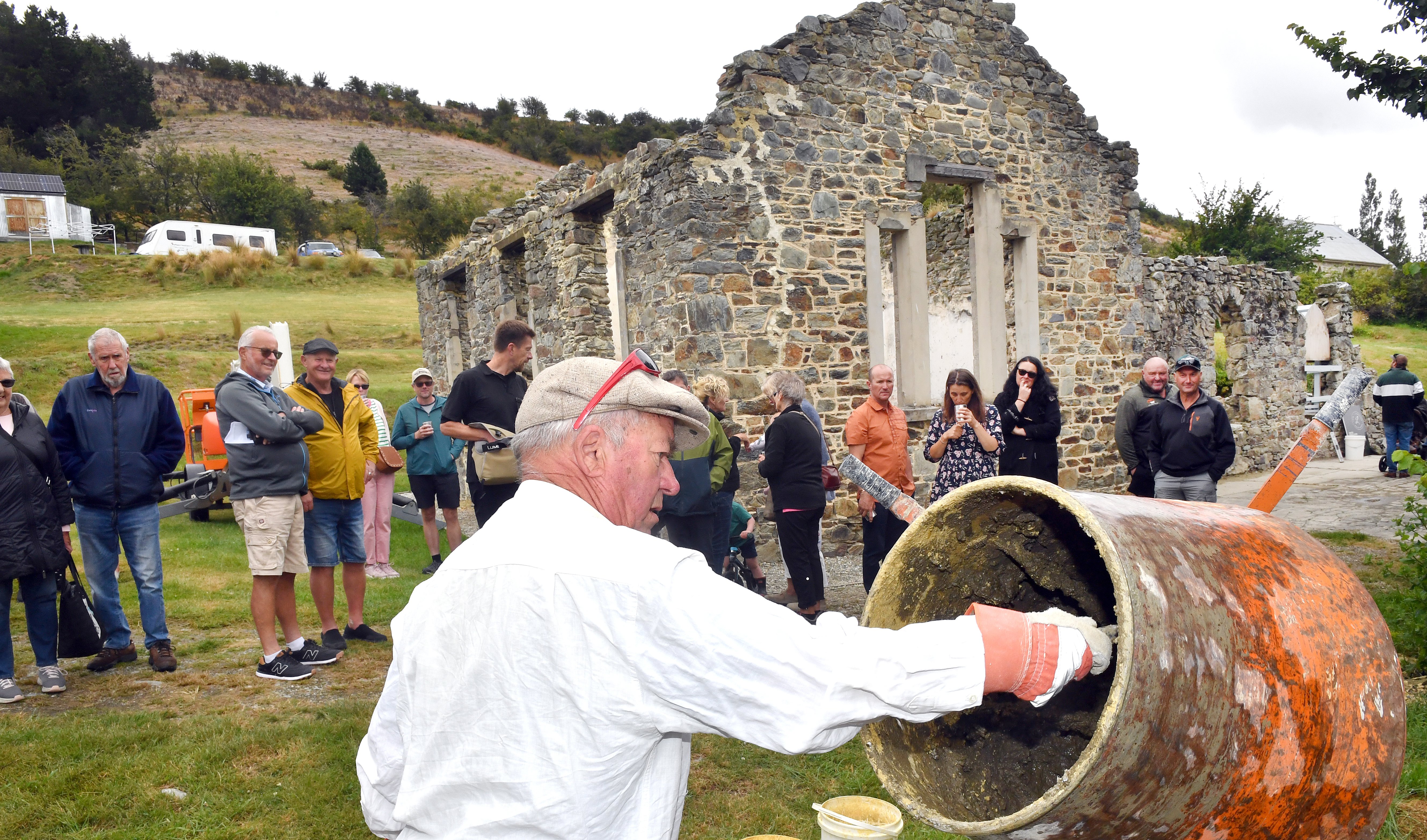 Heritage stonemason Keith Hinds mixes up another batch of lime mortar on Saturday to help...