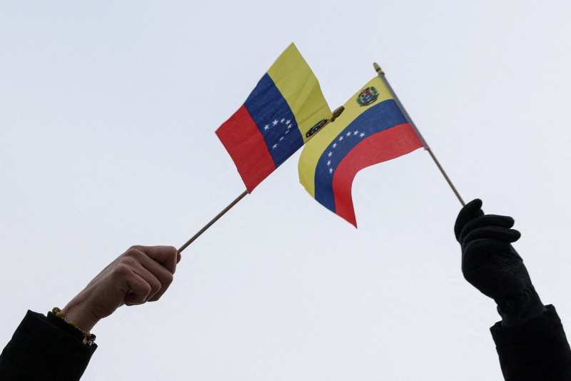 Demonstrators celebrate after US President Trump said the US has struck Venezuela and captured...