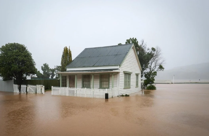 Floodwaters surround a home in Akaroa. Photo: RNZ