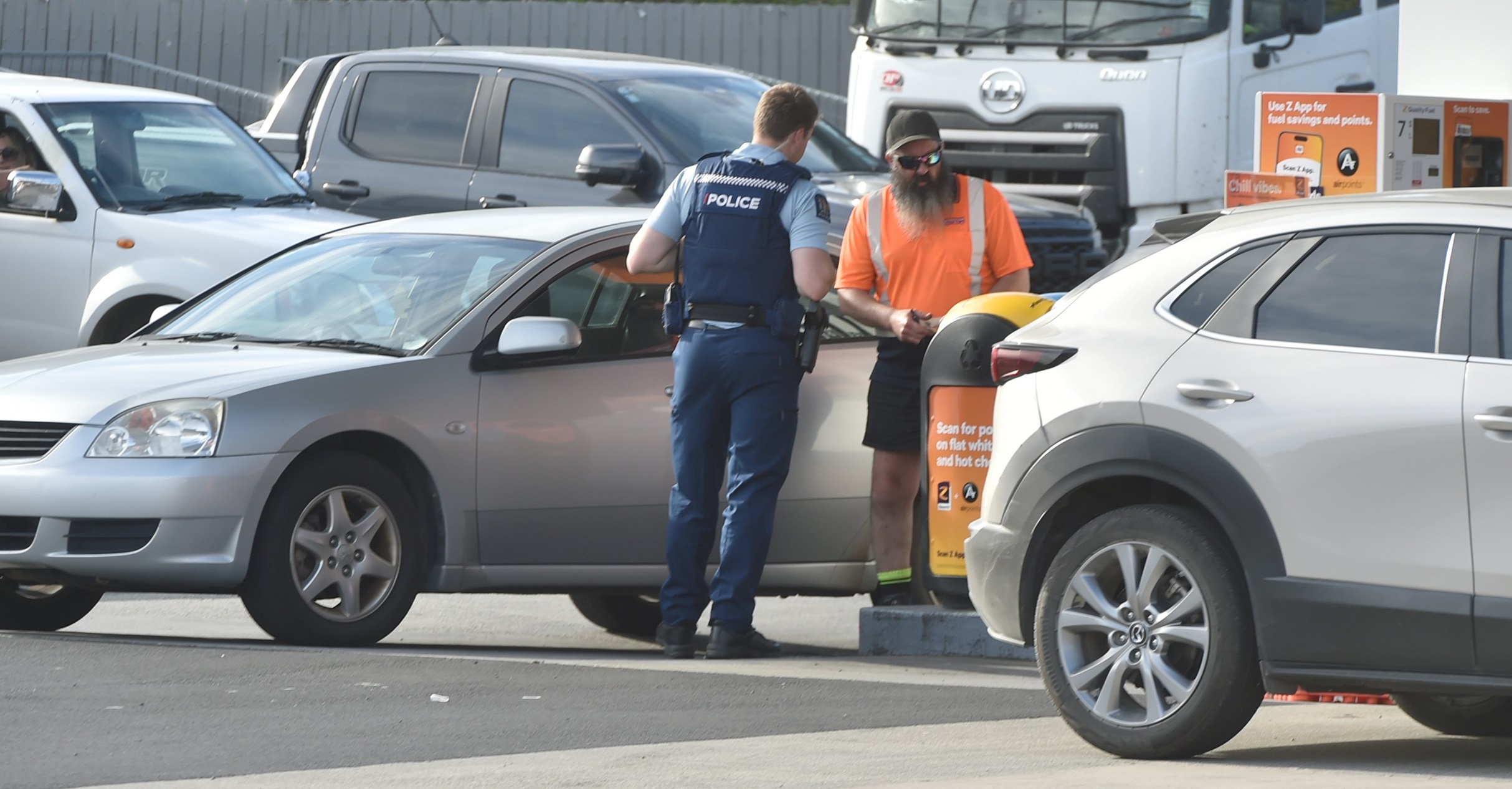 A police officer stands by a vehicle at the Z service station in Kaikorai Valley Rd last night....