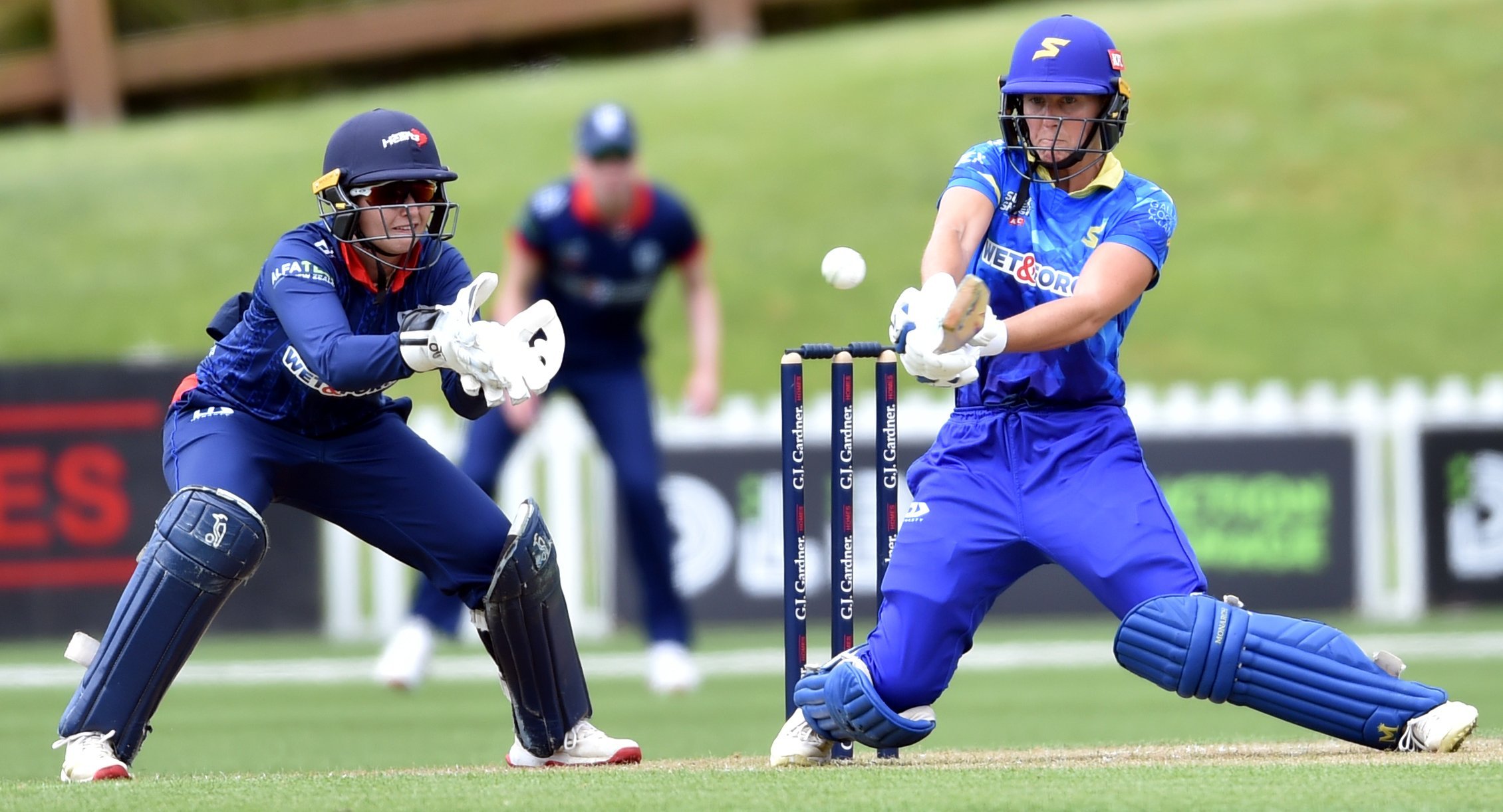 Otago Sparks batter Caitlin Blakely plays a reverse sweep shot, watched by Auckland wicketkeeper...