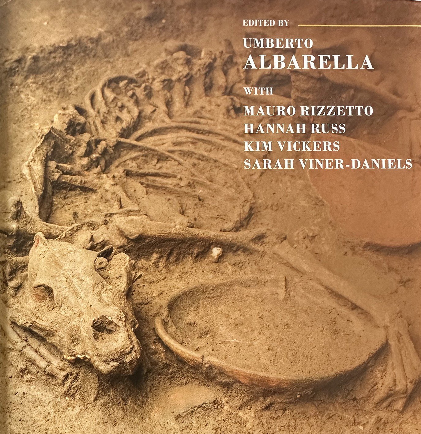 A dog appears to cradle its food bowl in this image used for the cover of the Oxford Handbook of...