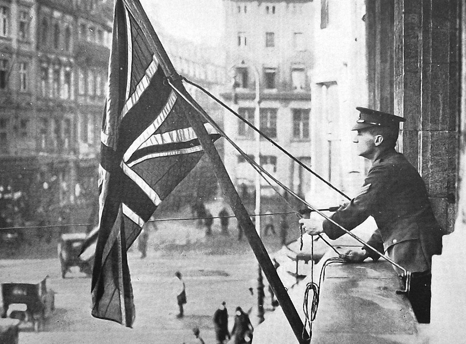 Quartermaster-Sergeant Greenwood hauls down the Union Jack from the British general headquarters...