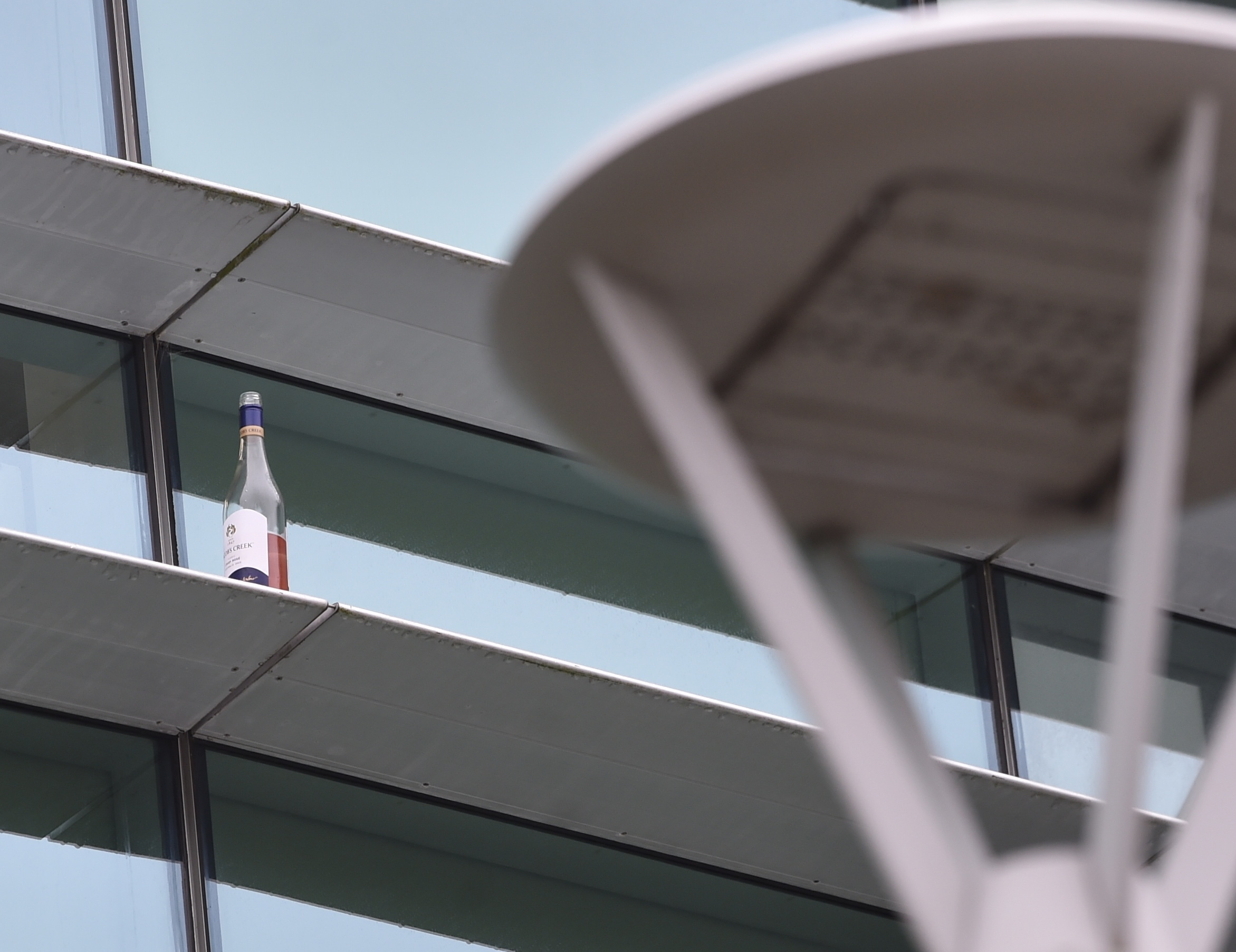 A wine bottle can be seen sitting on the ledge the man is believed to have fallen from. Photo:...