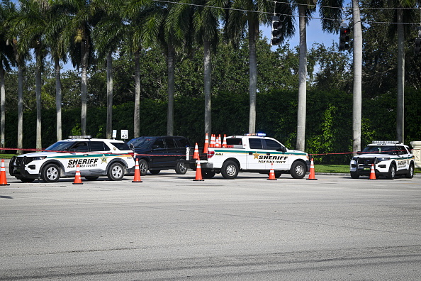 Law enforcement personnel investigate the area around Trump International Golf Club following an...