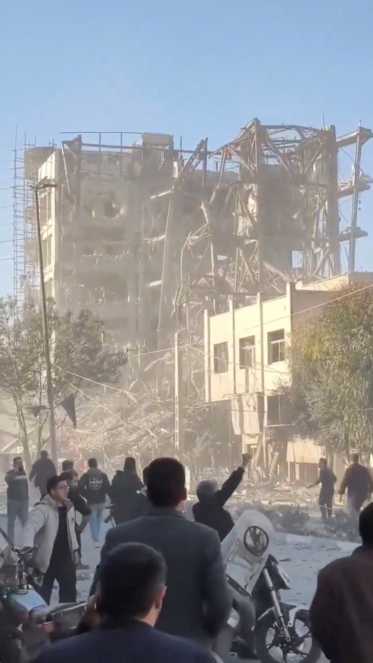 People stand near the destroyed building of Iran's Assembly of Experts in Qom, Iran. Photo:...