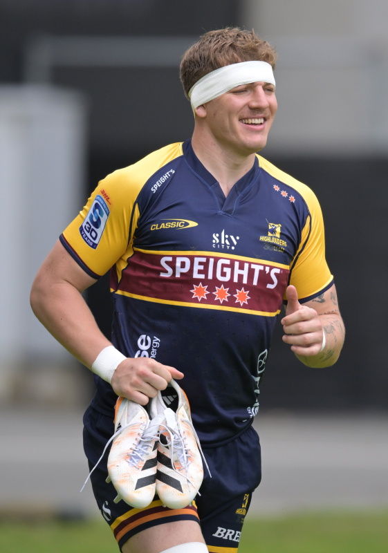Fabian Holland smiles as he carries his boots at a Highlanders training session earlier this year...