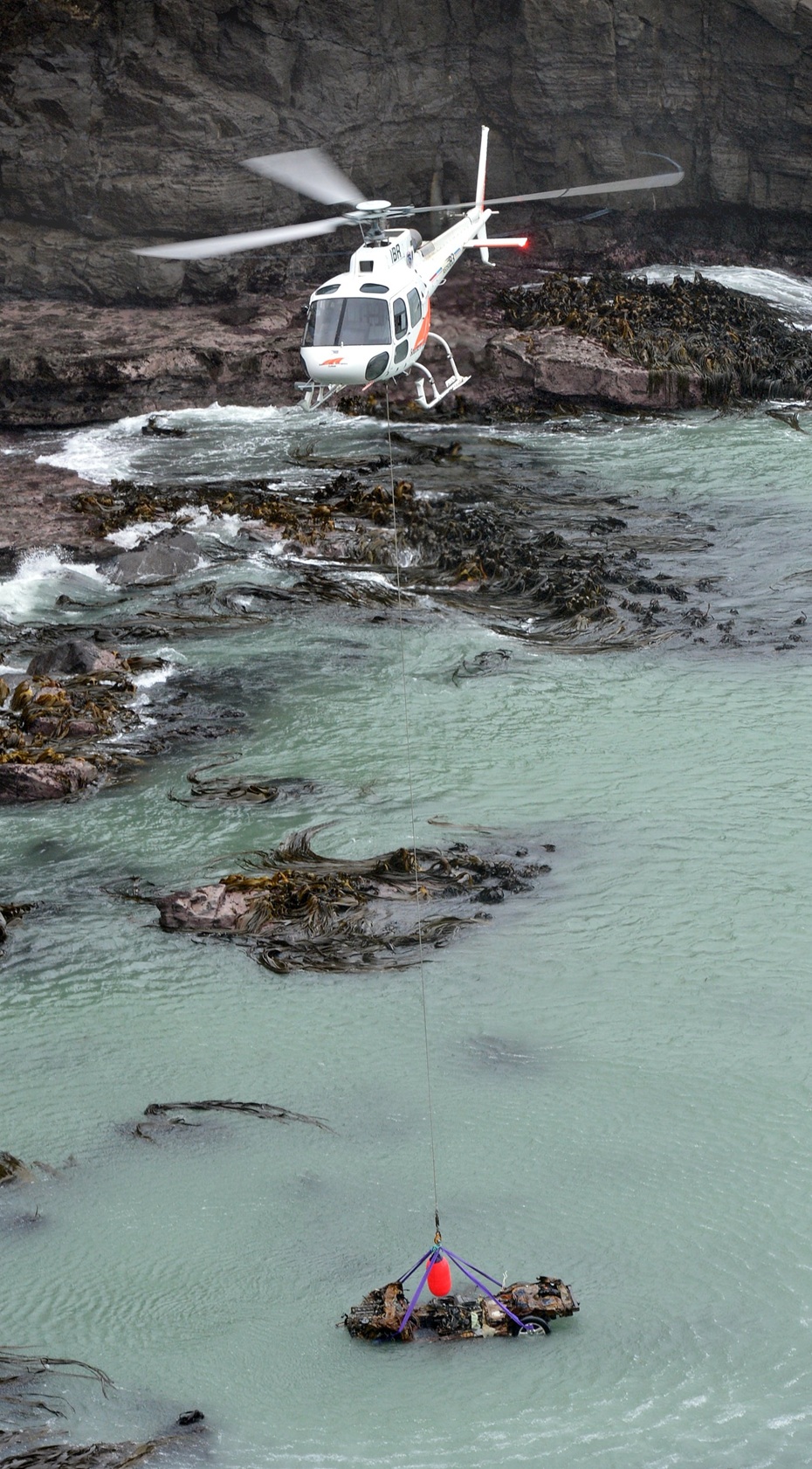 A helicopter winches John Beckenridge’s car from the ocean in May 2015. Photo: Stephen Jaquiery