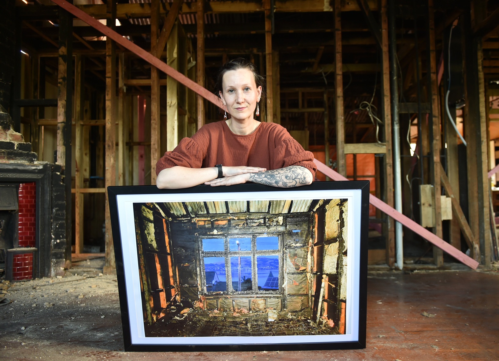 Standing in her fire-damaged home which is being rebuilt, Susan Wardell holds one of her...