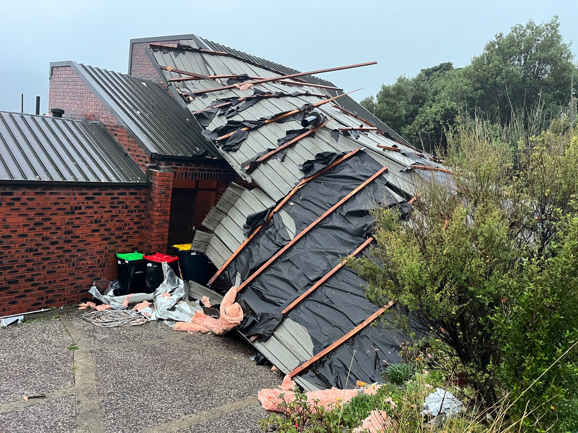 The roof of a Connell St house, in the Dunedin suburb of Waverley, lies on the drive after being...