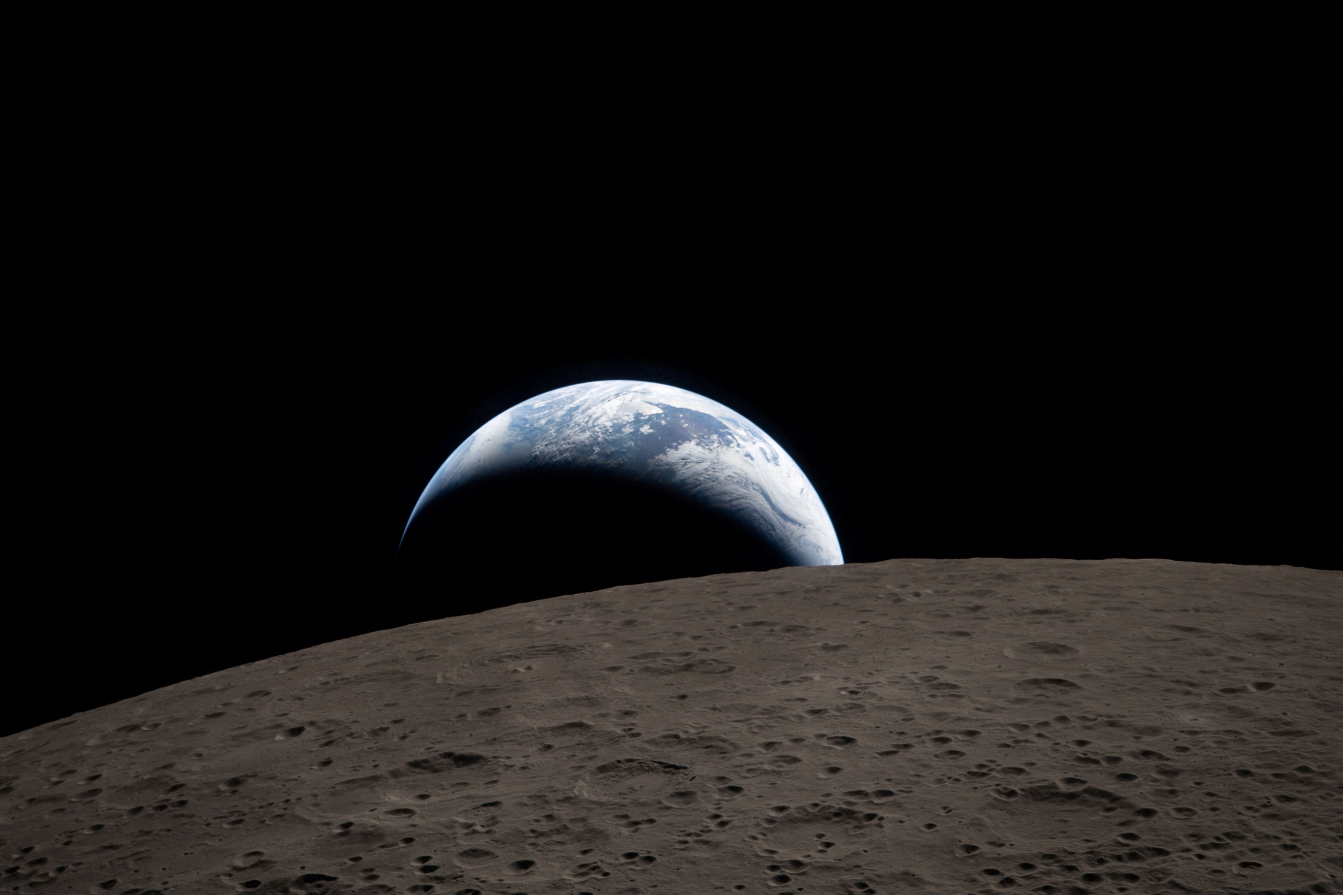 A view of Earth, partially hidden behind the Moon, captured through the Orion spacecraft window....