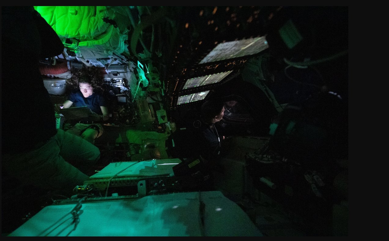 Nasa astronaut Christina Koch reads on a tablet in the dimly lit Orion crew capsule. Photo: Nasa