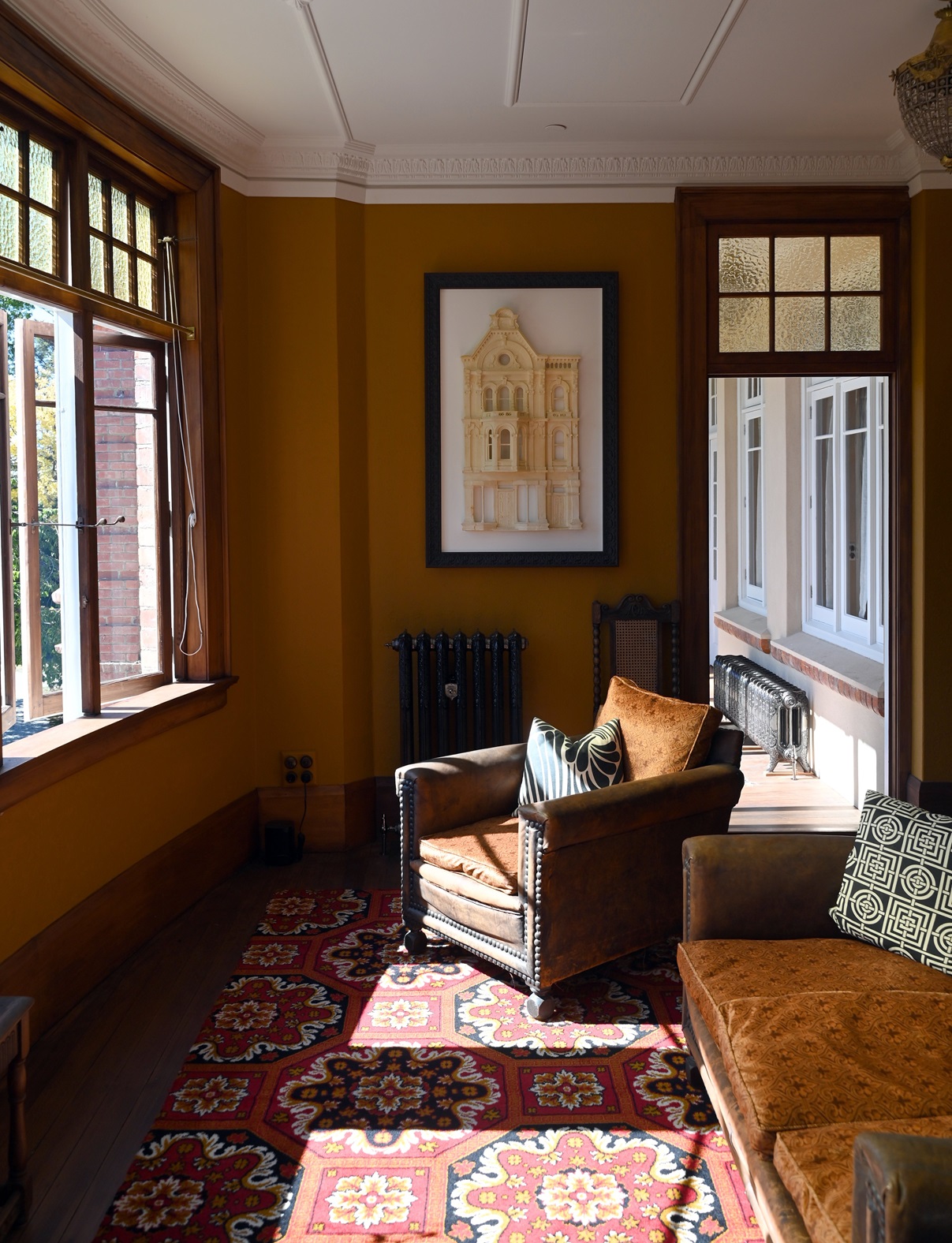 The series of bay windows in the first-floor sunroom give the feeling of standing on the bridge...