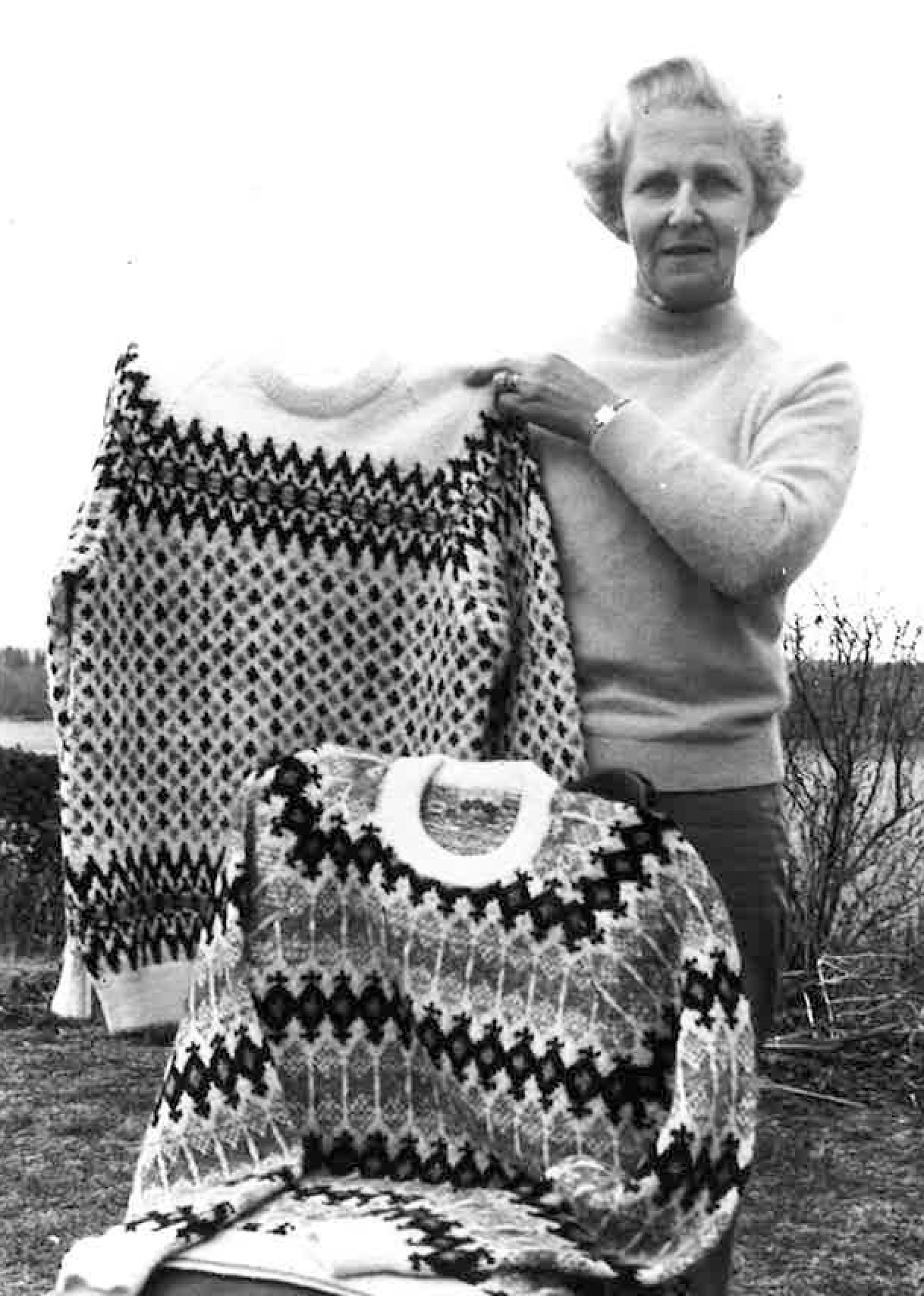 Mrs Muldrew holds up the jumpers she knitted for Swedish royalty.