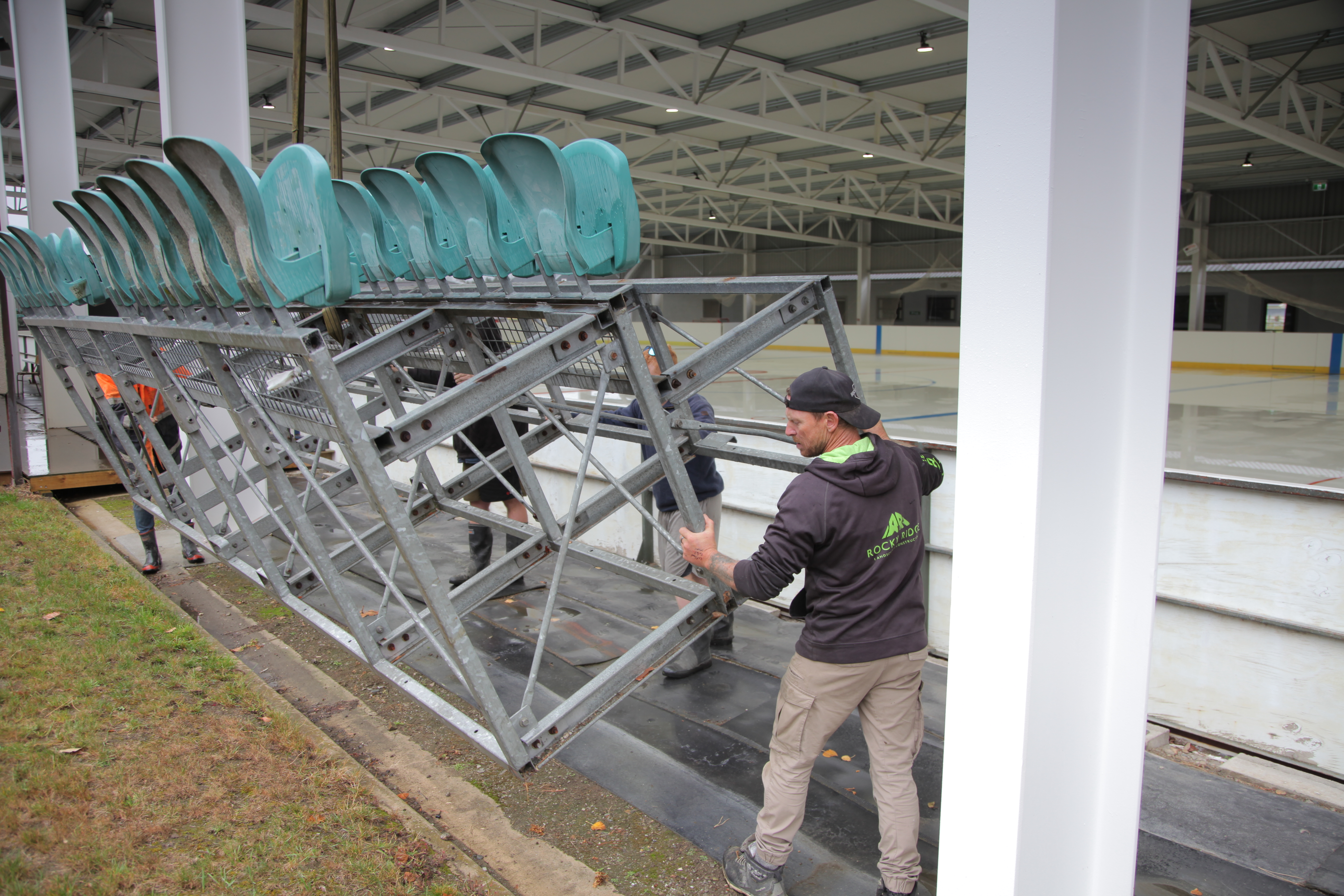 Image 8745 caption : (L-R)  Richard Wallis  guides the new stands into position at the Inline Ice...
