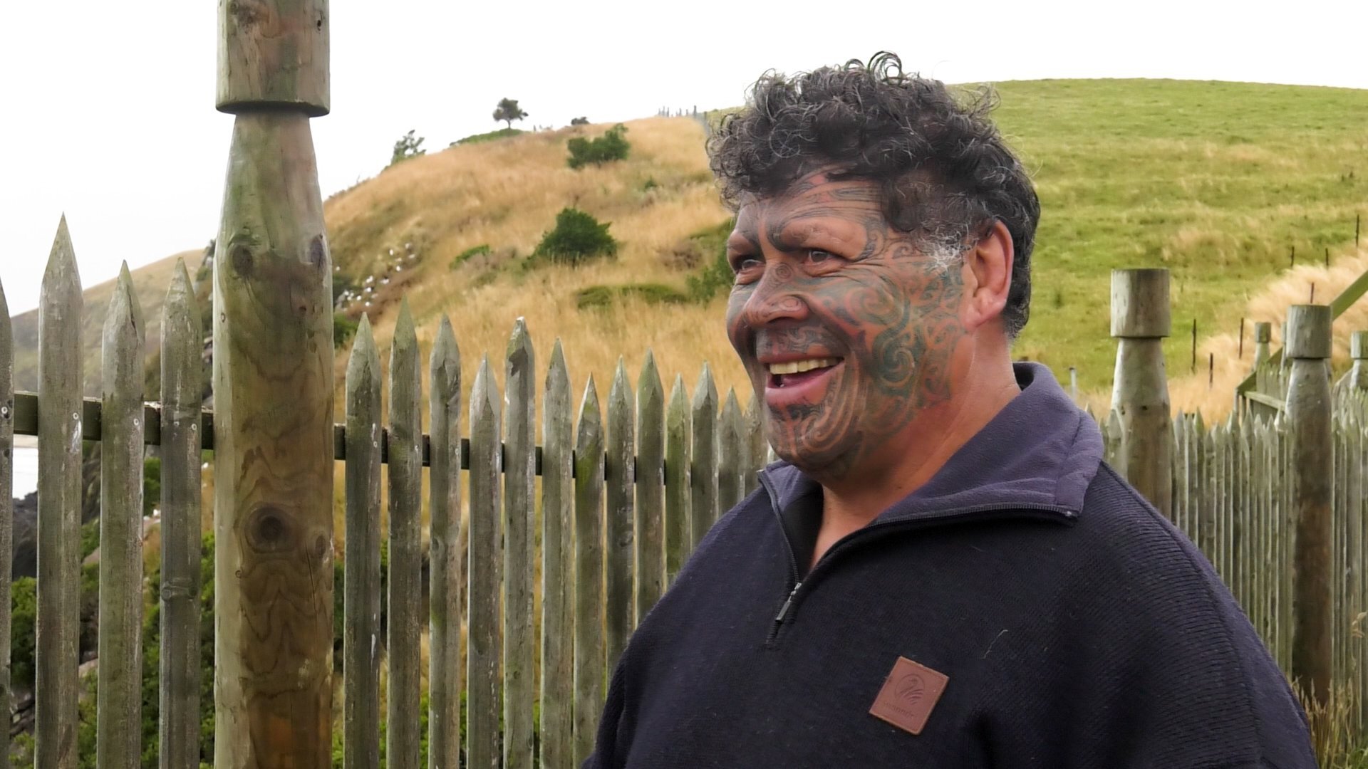 Patrick Herewini-Tipa at the palisaded neck of Te Raka-a-Hineātea, with the terraced hill of the...