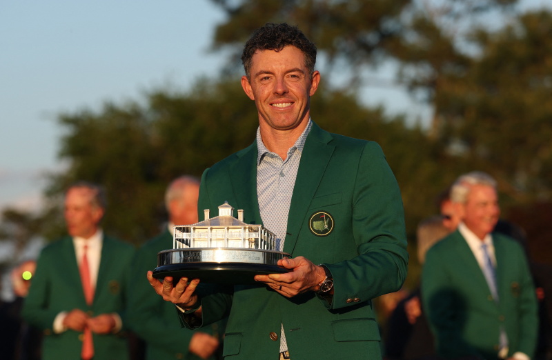 Rory McIlroy celebrates with his green jacket and the trophy after winning The Masters. Photos:...