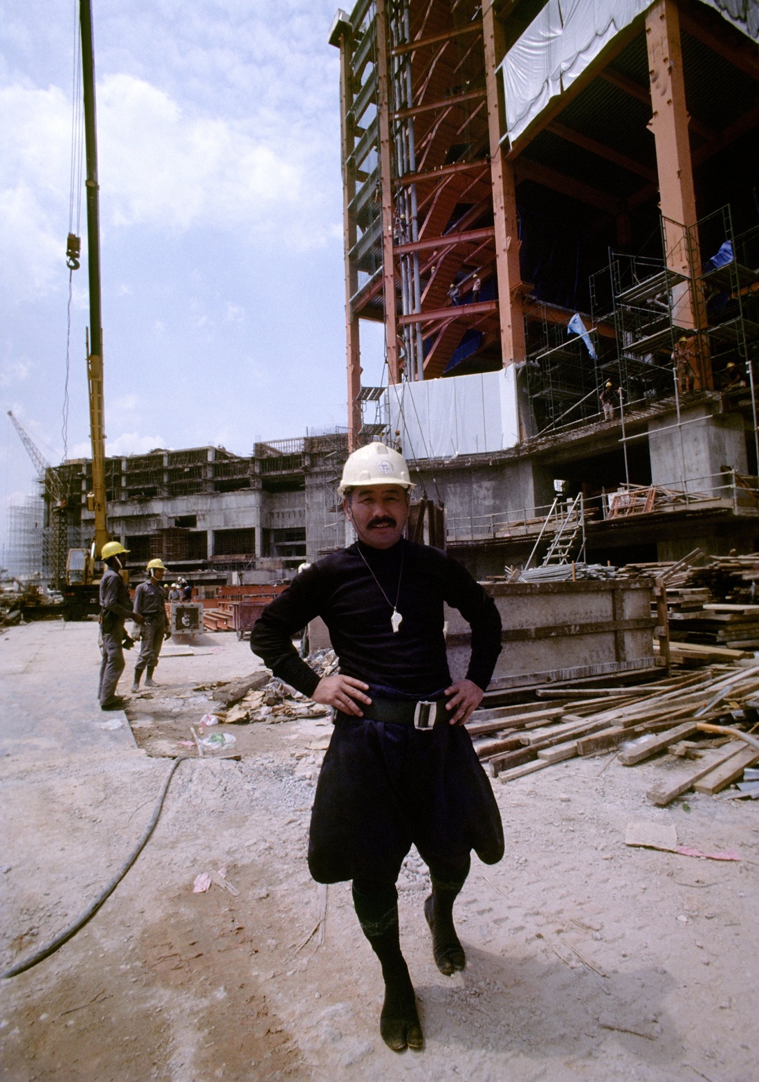 A Japanese construction worker in traditional builders’ uniform wearing jika split-toe work boots...
