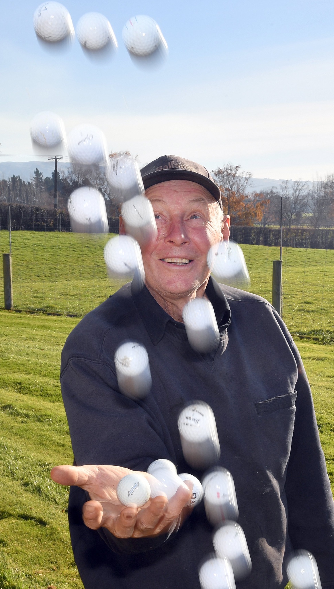 Taieri farmer Bill Nichol tosses some of the golf balls that have ended up on his side of the...