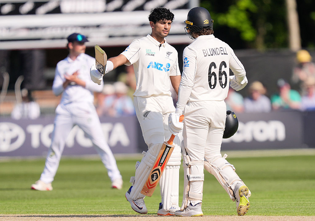 New Zealand's Rachin Ravindra celebrates with Tom Blundell after reaching his century against...