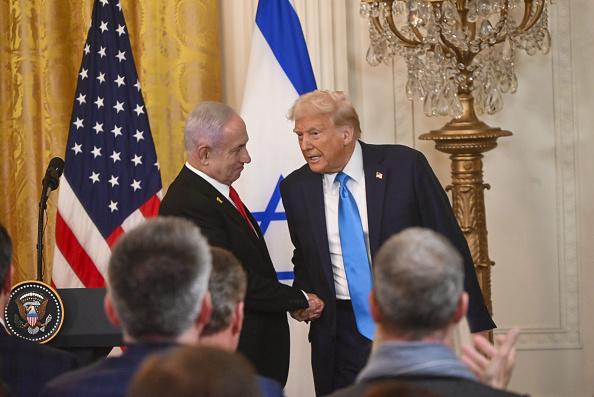 Israeli Prime Minister Benjamin Netanyahu (L) and US President Donald Trump (R) and (L) shake...