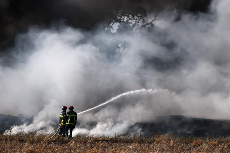 French firefighters work to extinguish a fire near a farm in Grand-Auverne, as drought worsens in...