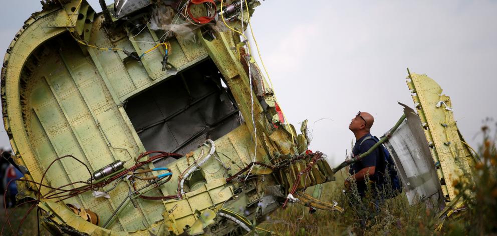 A Malaysian air crash investigator inspects the remains of flight MH17 in Donetsk region of Ukraine. Photo: Reuters  