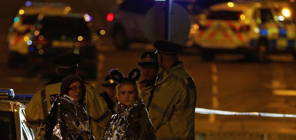Two concert-goers wrapped in thermal blankets at the scene. Photo: Reuters 
