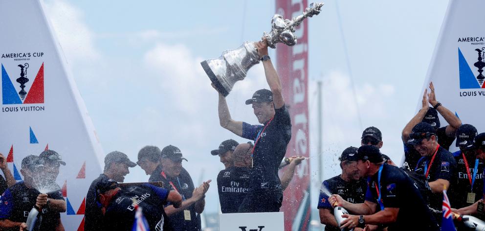 Team NZ's helmsman Peter Burling celebrates winning the America's Cup trophy. Photo: Reuters 