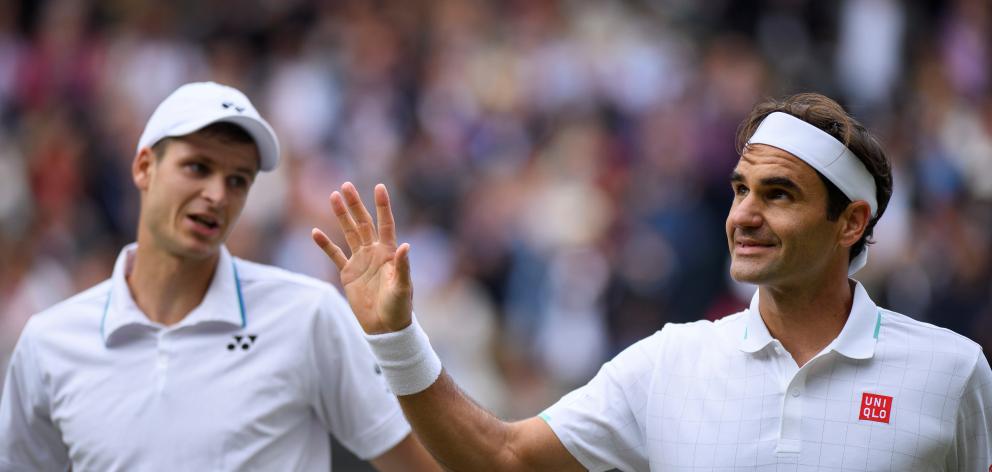 Roger Federer waves to the Centre Court crowd after losing his quarterfinal match against Hubert...