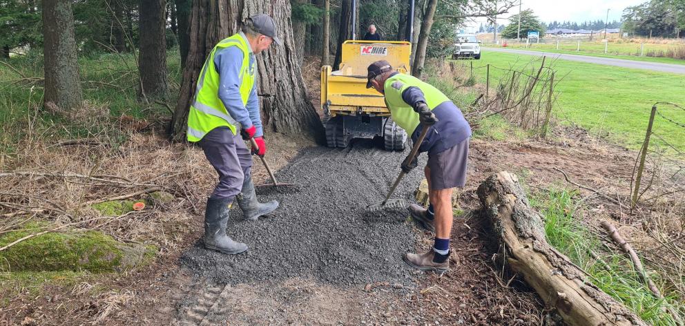 Methven Lions Club members Mike MarKillie and Ron Smith smoothing out the new shingle layer on...