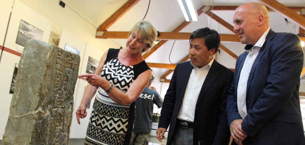 Cromwell Museum trustee Joan Lawrence (left) describes an old Cantonese headstone to Chinese consul-general Jin Zhijian and Central Otago Mayor Tim Cadogan yesterday. Photo by Jono Edwards.