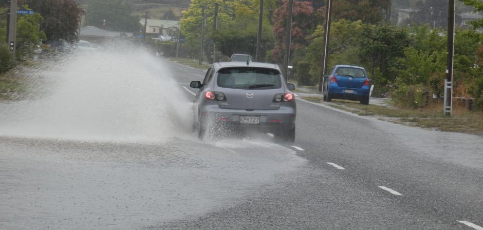 A car negotiates surface flooding in Hazlett St, Clyde. Photo: Jared Morgan