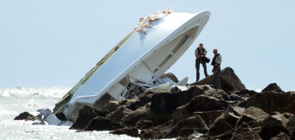 Investigators look over the overturned boat on a jetty in which Miami Marlins pitcher Jose...